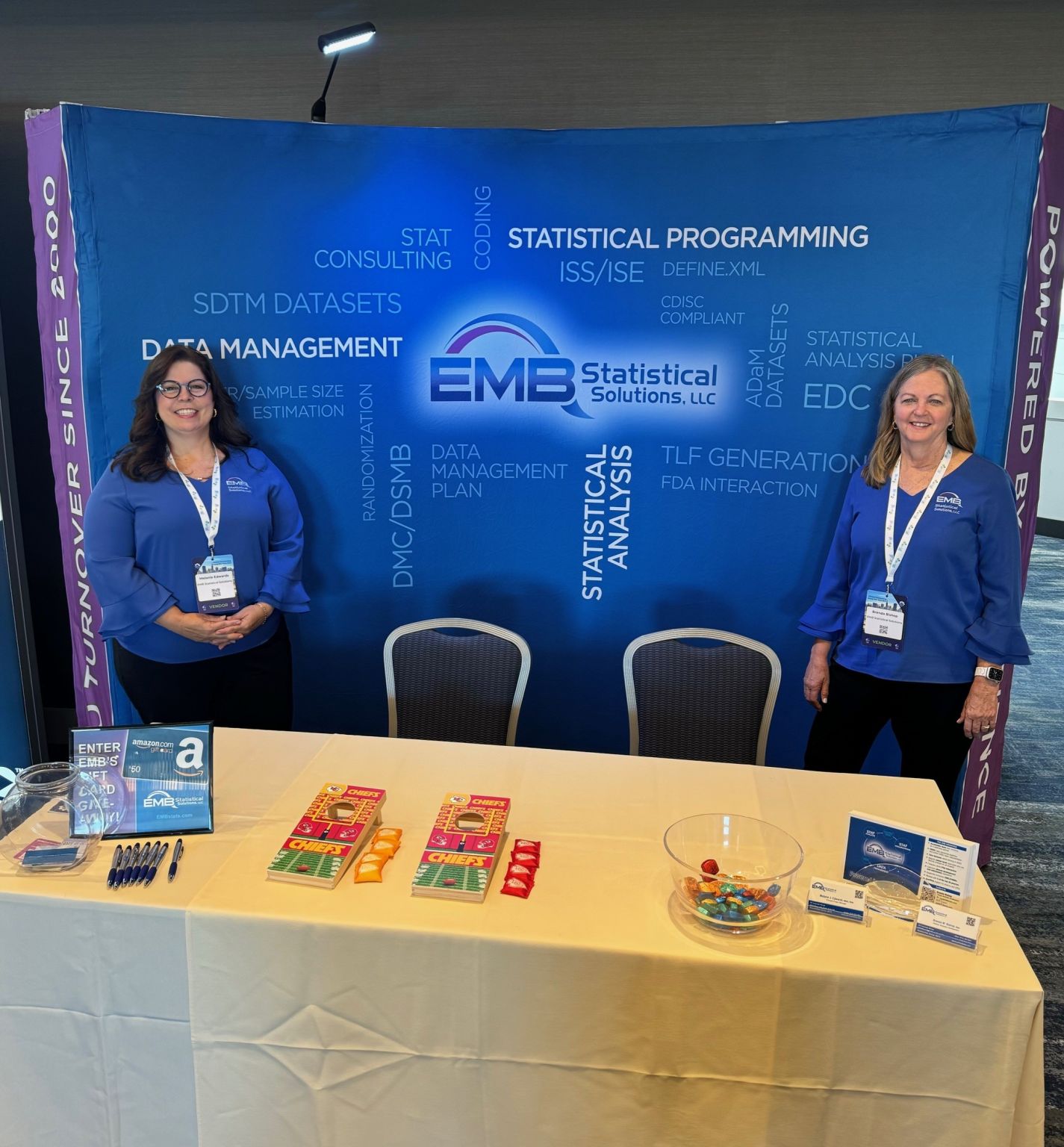 Two women standing at EMB exhibit booth